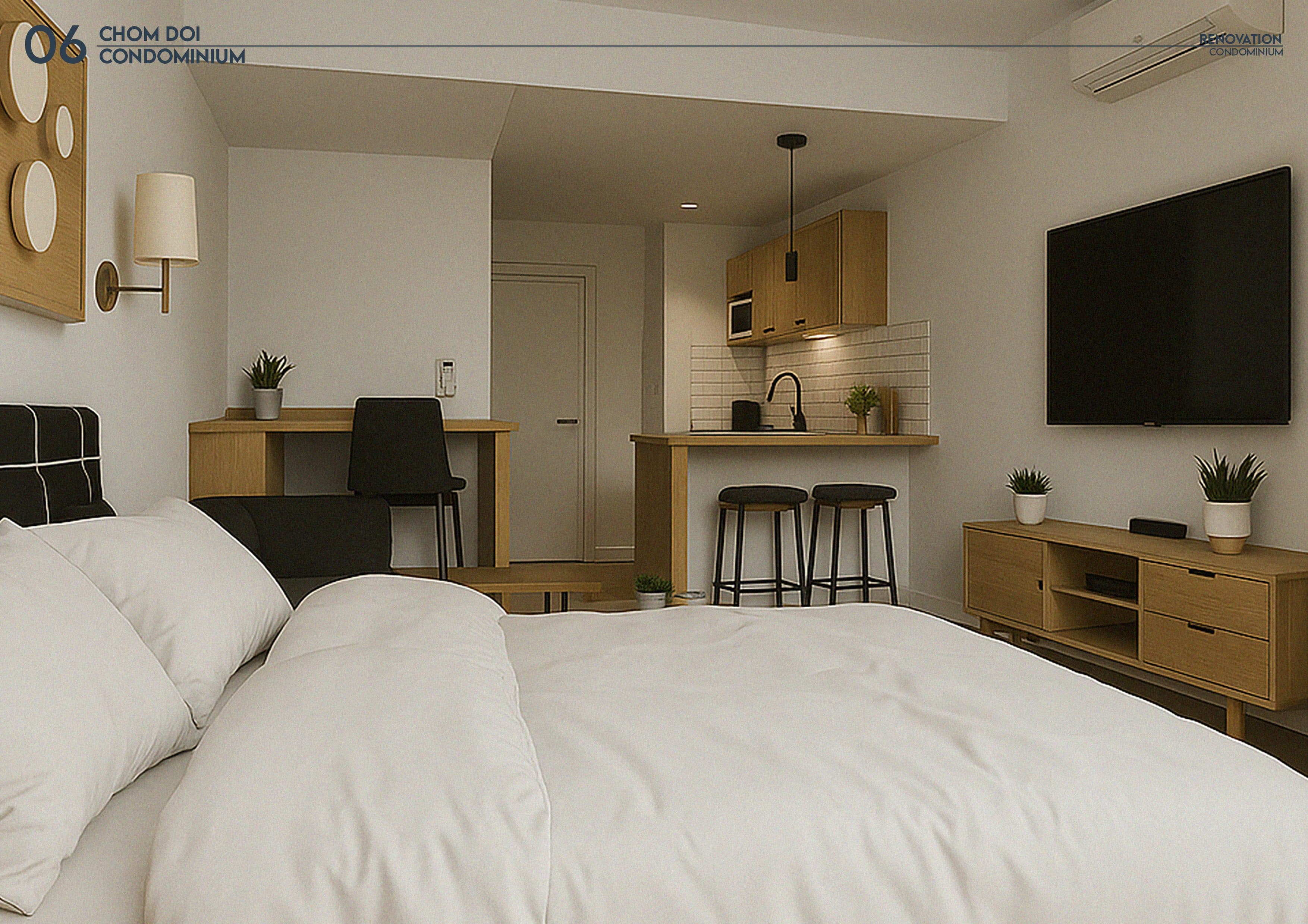 Perspective of the renovated studio, looking past the bed to the kitchenette counter and entrance